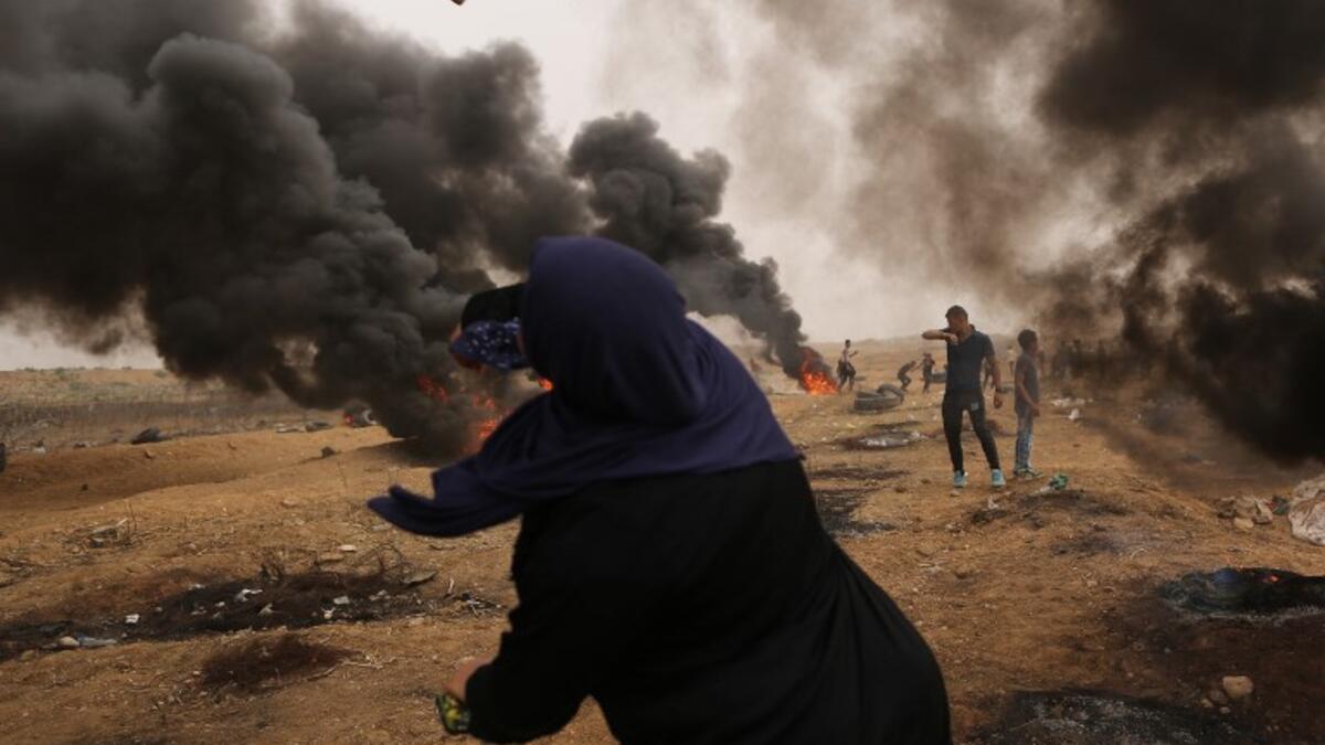 A Palestinian woman protester hurls stones towards Israeli forces during clashes along the border with the Gaza strip east of Gaza City on May 4, 2018, on the sixth straight Friday of mass demonstrations calling for the right to return to their historic homelands. (MAHMUD HAMS / AFP)