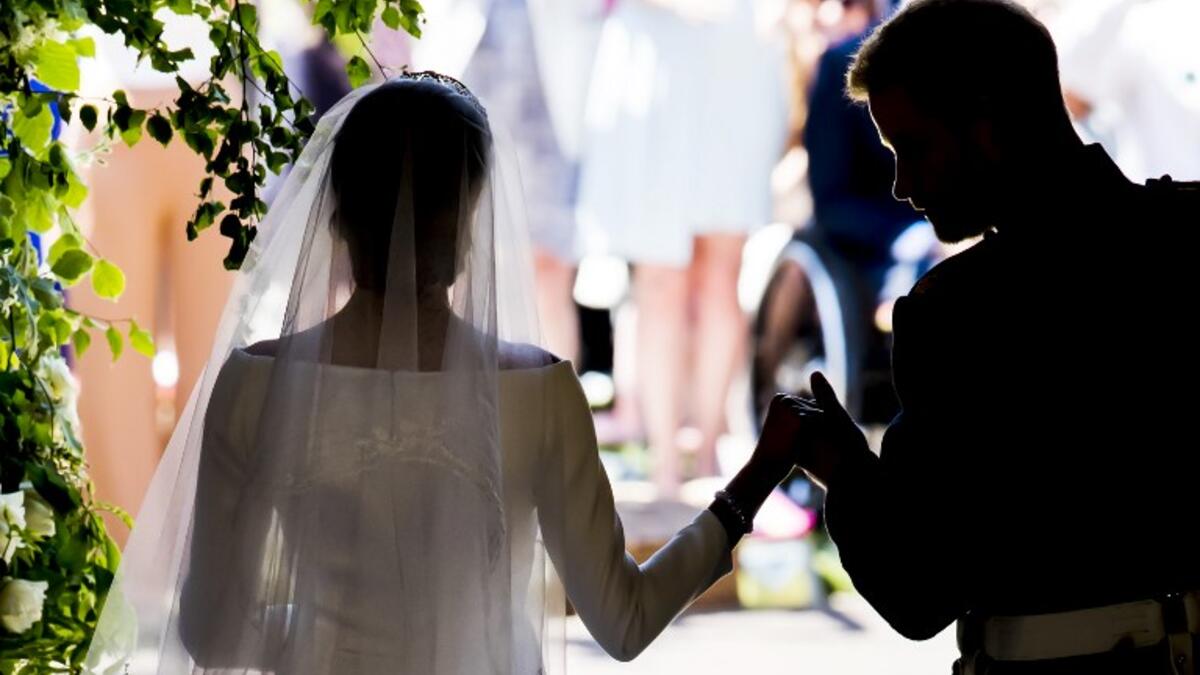 Britain's Prince Harry, Duke of Sussex and his wife Meghan, Duchess of Sussex emerge from the West Door of St George's Chapel, Windsor Castle, in Windsor, on May 19, 2018 after their wedding ceremony. 
Danny Lawson/ AFP