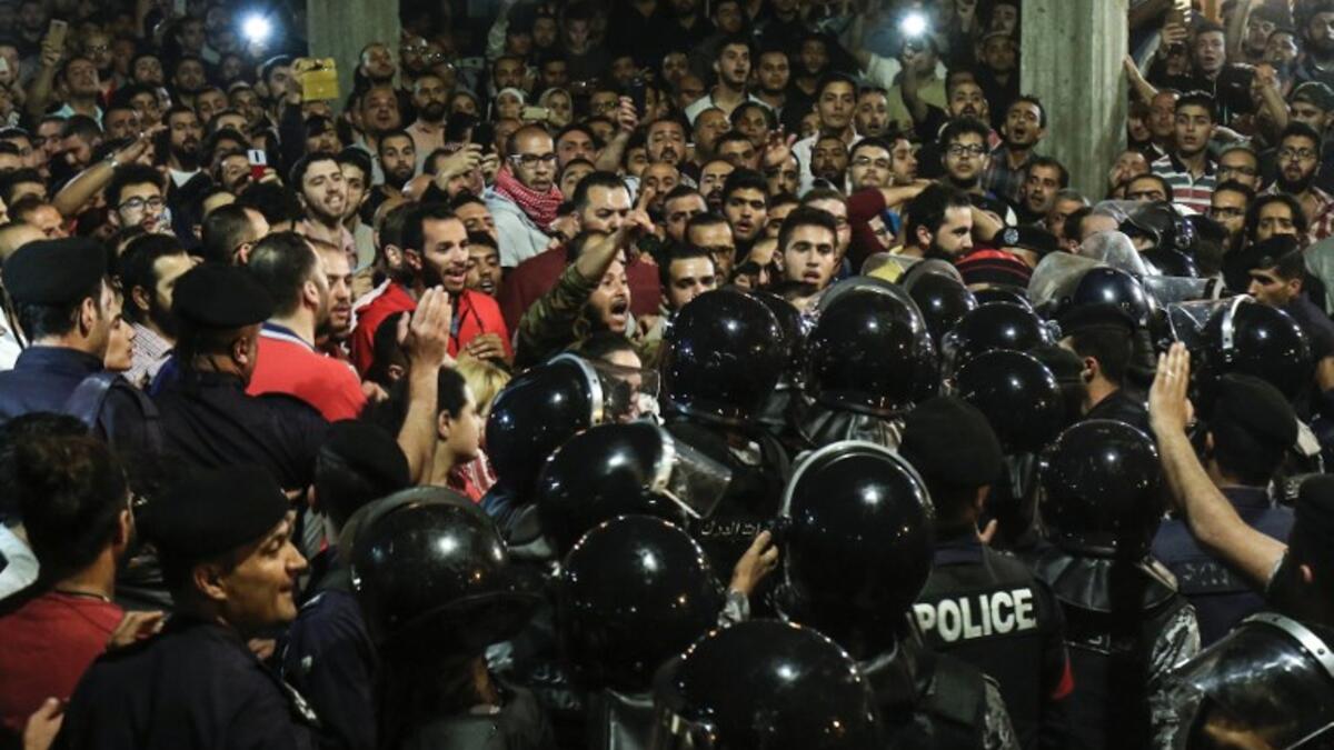 Jordanian protesters shout slogans before members of the gendarmerie and security forces during a demonstration outside the Prime Minister's office in the capital Amman late on June 2, 2018/AFP
