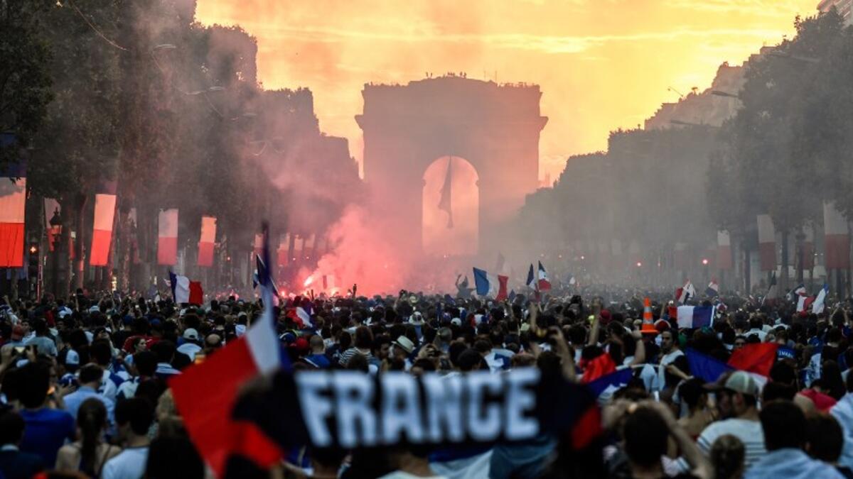 People celebrate France's victory in the Russia 2018 World Cup final football match between France and Croatia, on the Champs-Elysees avenue in Paris on July 15, 2018. 
Eric FEFERBERG / AFP