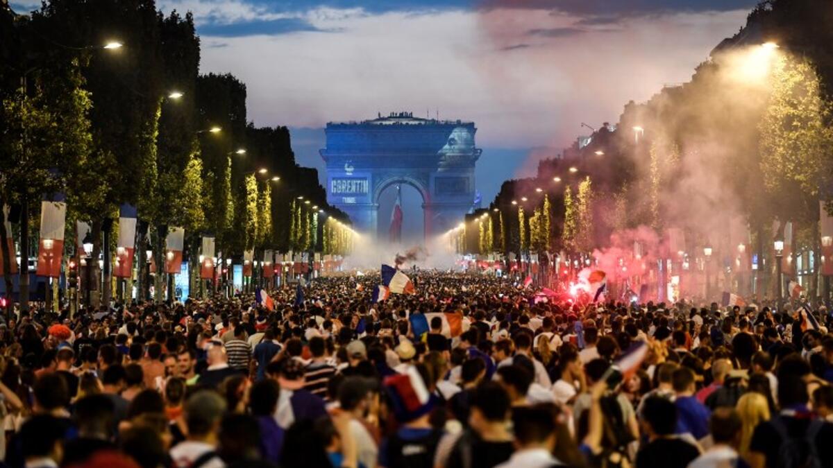 People celebrate France's victory in the Russia 2018 World Cup final football match between France and Croatia, on the Champs-Elysees avenue in Paris on July 15, 2018. 
Eric FEFERBERG / AFP