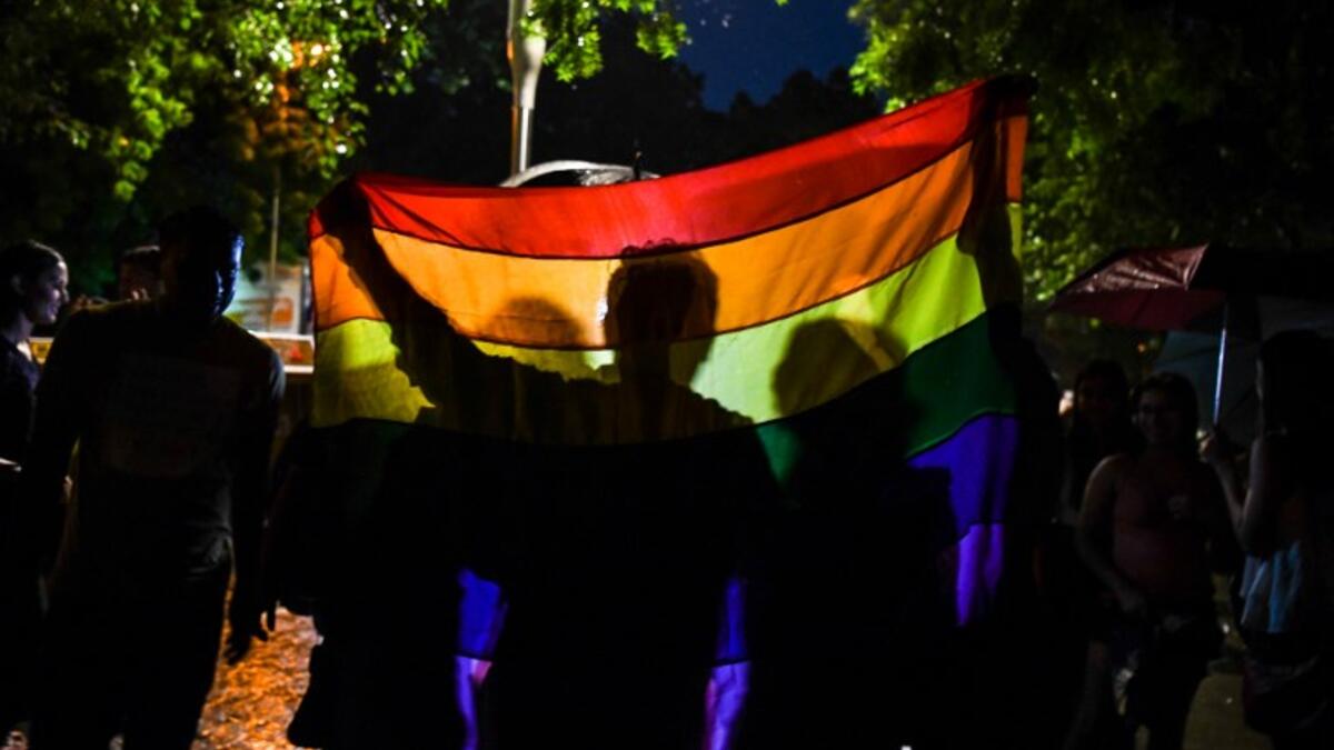 Indian members and supporters of the lesbian, gay, bisexual, transgender (LGBT) community celebrate the Supreme Court decision to strike down a colonial-era ban on gay sex, during heavy rainfall in New Delhi on September 6, 2018. 
CHANDAN KHANNA / AFP