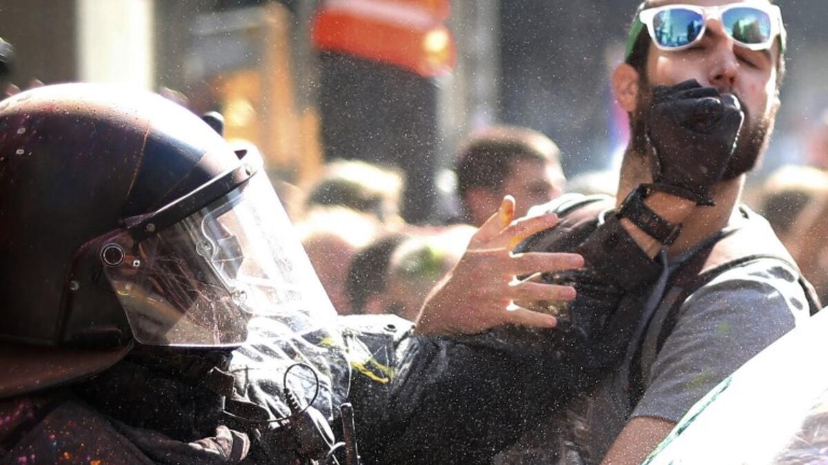 A Catalan regional police 'Mosso D'Esquadra' officer hits a separatist protester during a counter-protest against a demonstration in support of Spanish police in Barcelona on September 29, 2018. 
Pau Barrena / AFP