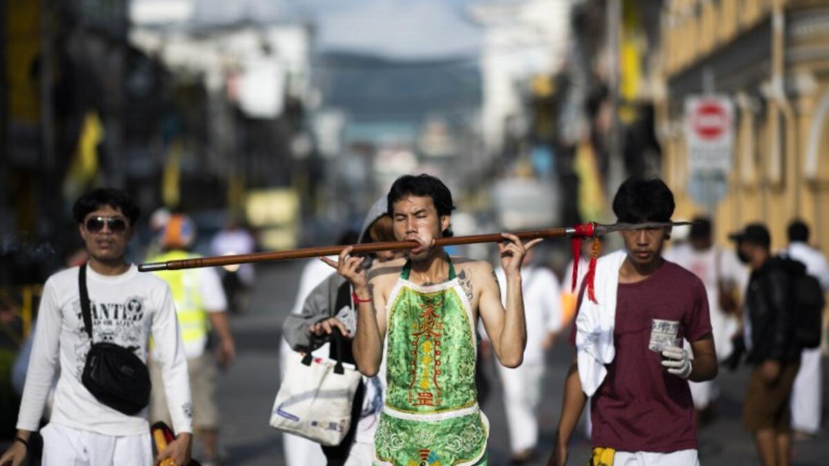 A devotee of the Loem Hu Thai Su shrine parades with a spear pierced through his cheek during the annual Vegetarian Festival in Phuket on October 12, 2018. Jewel SAMAD/AFP