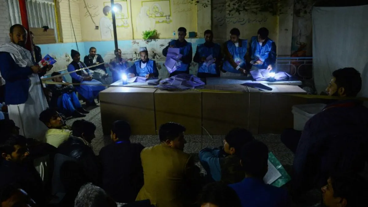In this photo taken on October 20, 2018, Afghan Independent Election Commission (IEC) officials count ballot papers at a polling centre for the country's legislative election in Herat province. 
HOSHANG HASHIMI / AFP