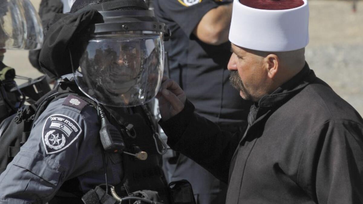A Druze man speaks to a member of the Israeli security forces during a protest by members of the Druze community against municipal elections. (JALAA MAREY / AFP)
