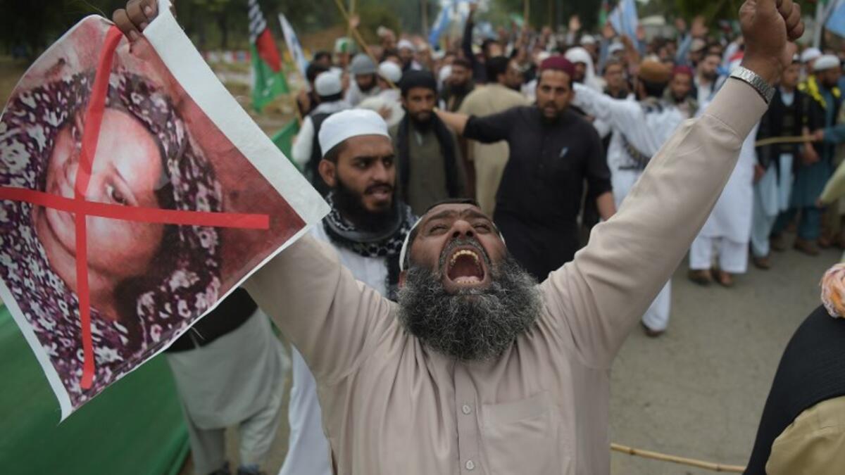 A Pakistani supporter of the Ahle Sunnat Wal Jamaat (ASWJ), a hardline religious party, holds an image of Christian woman Asia Bibi during a protest rally. (AAMIR QURESHI / AFP)