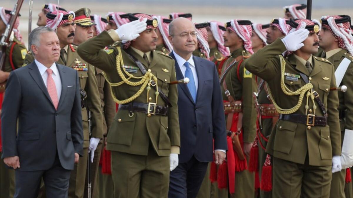 Iraq's President Barham Salih and Jordan's King Abdullah II (L) review an honor guard at Amman's military airport, on November 15, 2018. 
Khalil MAZRAAWI / AFP