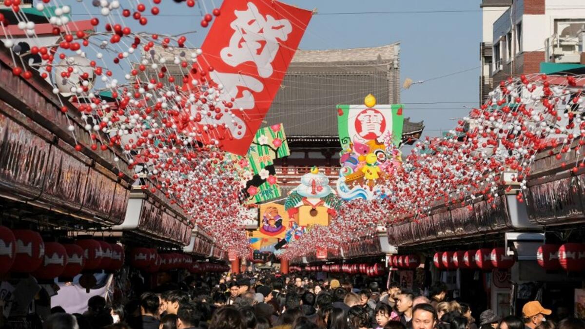 Visitors walk underneath New Year's Day decorations along the Nakamise shopping alley, the front approach to Sensoji Temple, in Tokyo on December 27, 2018. 
Kazuhiro NOGI / AFP