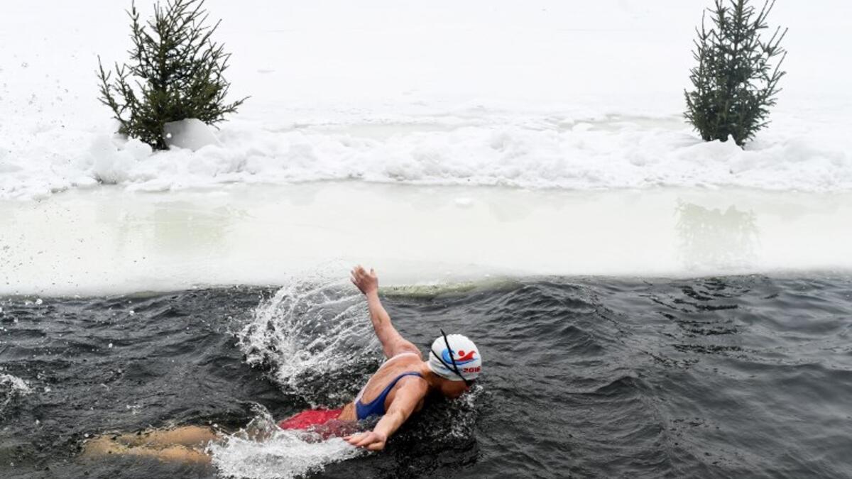 Natalya Seraya, the founder and chief of Moscow's ice swimming club "Walruses of the Capital", swims in a strip of water cut in the ice by the bank of the Moscow River on February 3, 2019. 
Kirill KUDRYAVTSEV / AFP