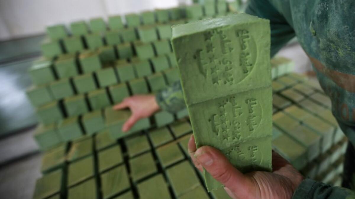 Syrian workers arrange olive soap bars in a factory on the outskirts of Aleppo 
LOUAI BESHARA / AFP