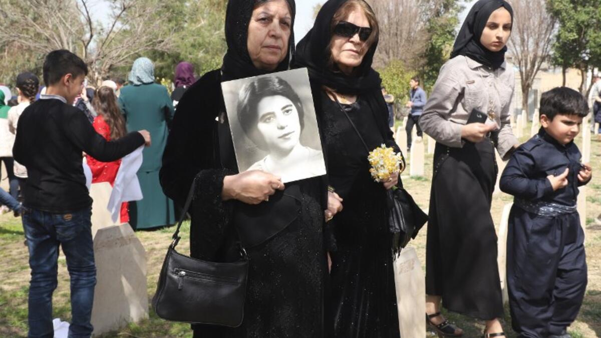 Iraqi-Kurds visit a grave site in Halabja near the monument for victims of the Halabja gas massacre 
Shwan MOHAMMED / AFP