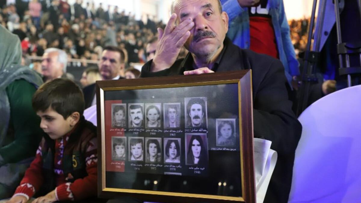 An Iraqi-Kurd carries portraits of relatives during a gathering in Halabja 
Shwan MOHAMMED / AFP