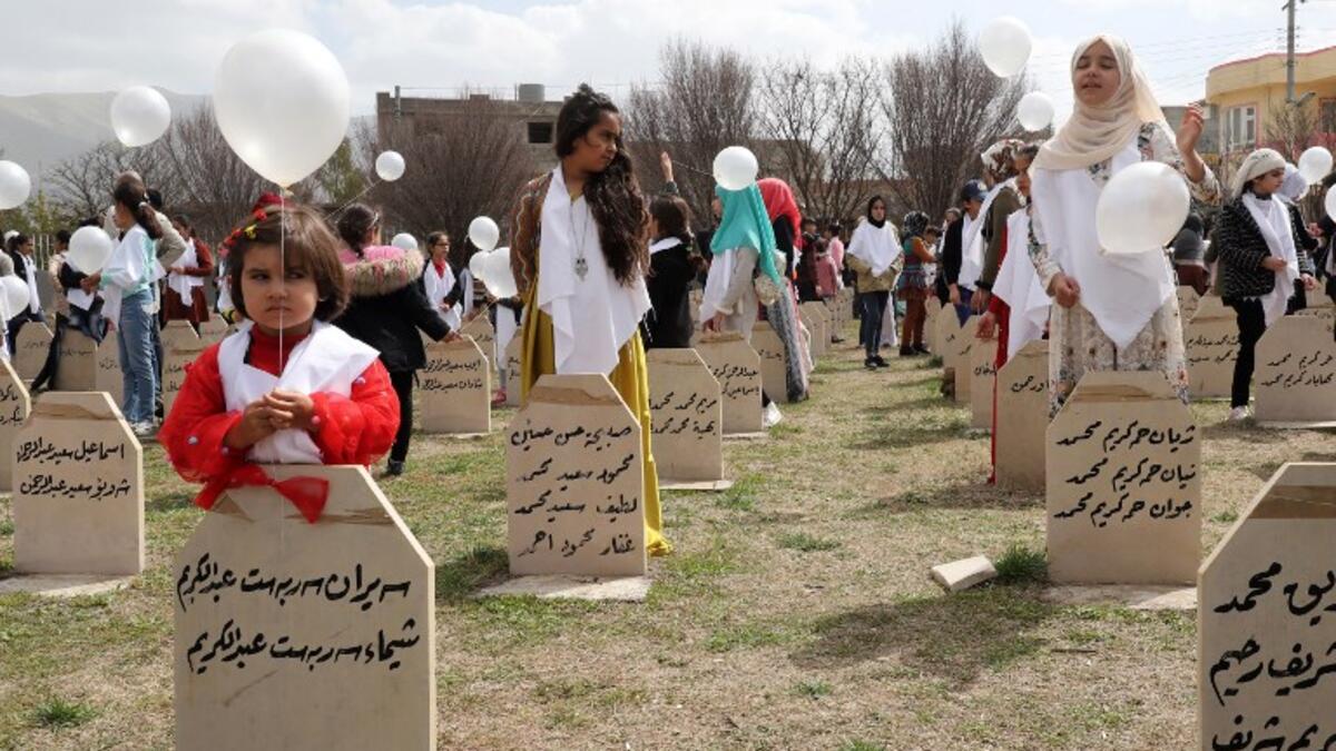 Iraqi-Kurds visit a grave site in Halabja near the monument for victims of the Halabja gas massacre 
Shwan MOHAMMED / AFP