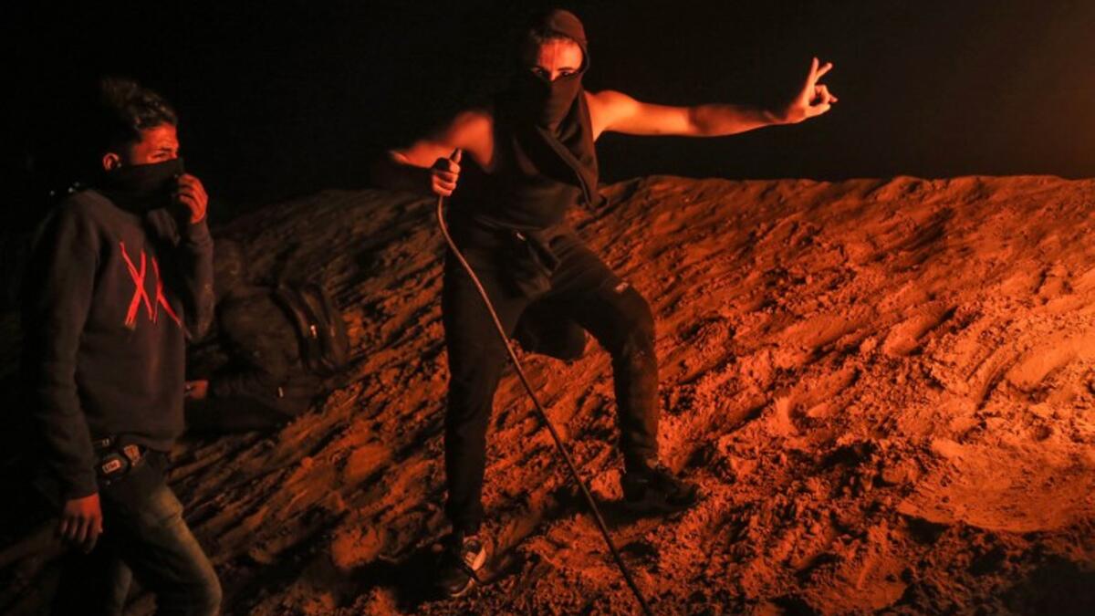 Palestinian protesters take part in a night demonstration near the fence along the border with Israel, in Rafah in the southern Gaza Strip
SAID KHATIB / AFP