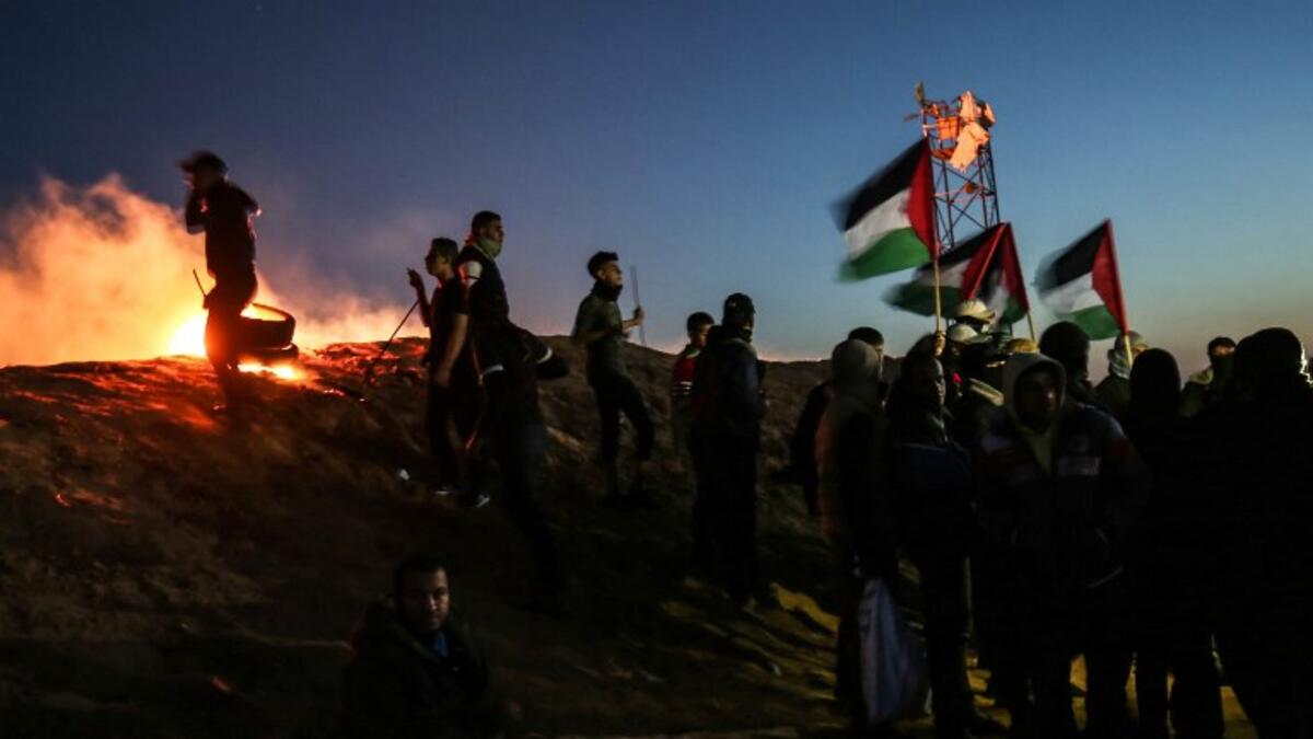 Palestinian protesters take part in a night demonstration near the fence along the border with Israel, in Rafah 
SAID KHATIB / AFP