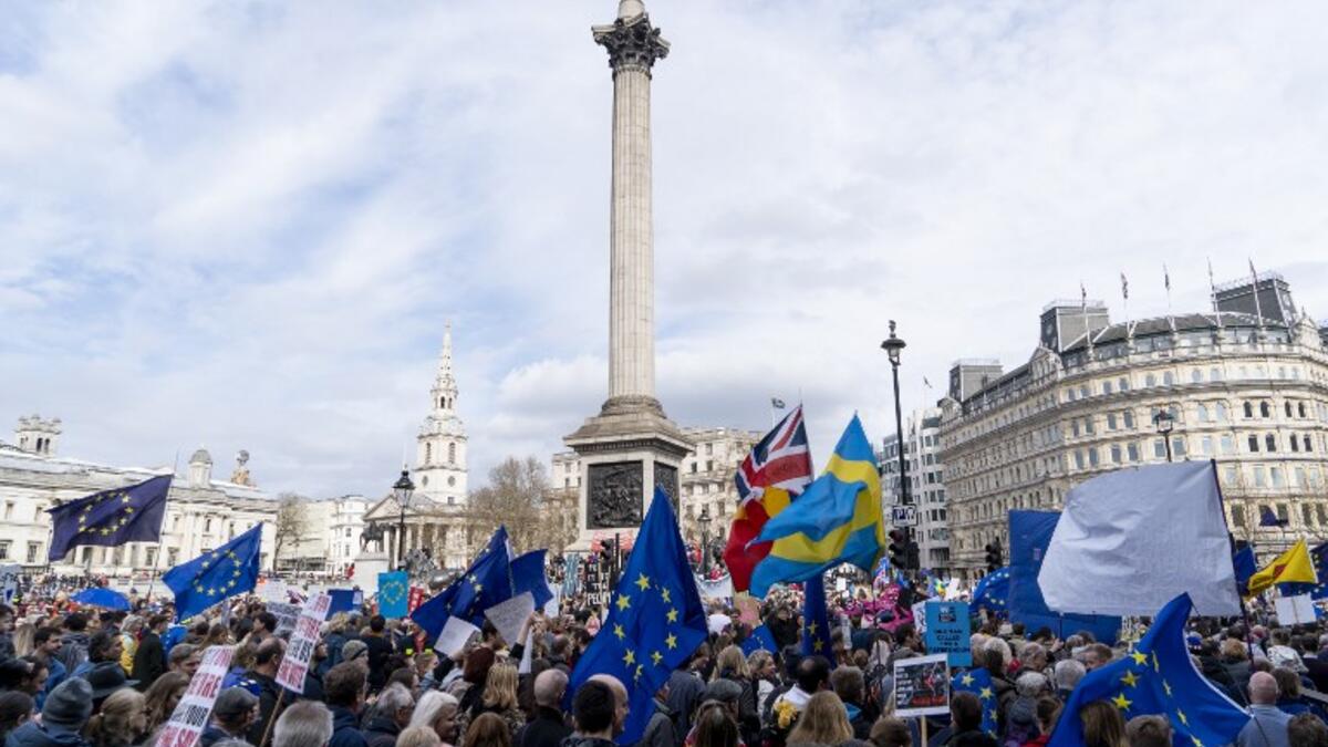 People hold up placards and European Union flags as they pass Trafalgar Square on a march and rally organised by the pro-European People's Vote campaign for a second EU referendum in central London on March 23, 2019.
Niklas HALLE'N / AFP