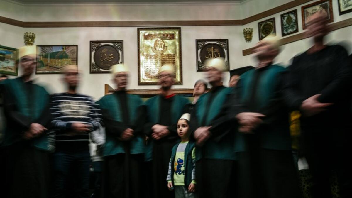 A boy looks on as he stands among Kosovo Dervishes during a ceremony in a prayer room in Gjakova
Gent SHKULLAKU / AFP