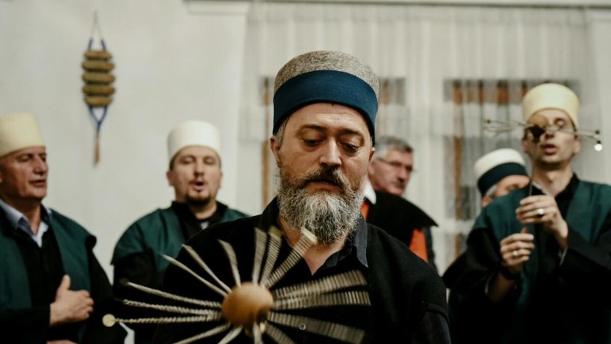 A Kosovo Dervish, adept of Sufism, a mystical form of Islam, swirls a needle before piercing his cheek during a ceremony in a prayer room
Gent SHKULLAKU / AFP
