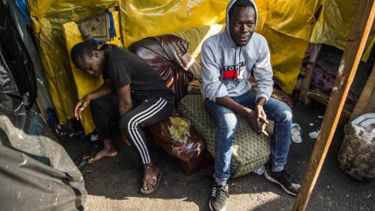 Sub-Saharan migrants sit by a make-shift tent at the Oulad Ziane migrant camp in Casablanca on March 27, 2019. 
FADEL SENNA / AFP