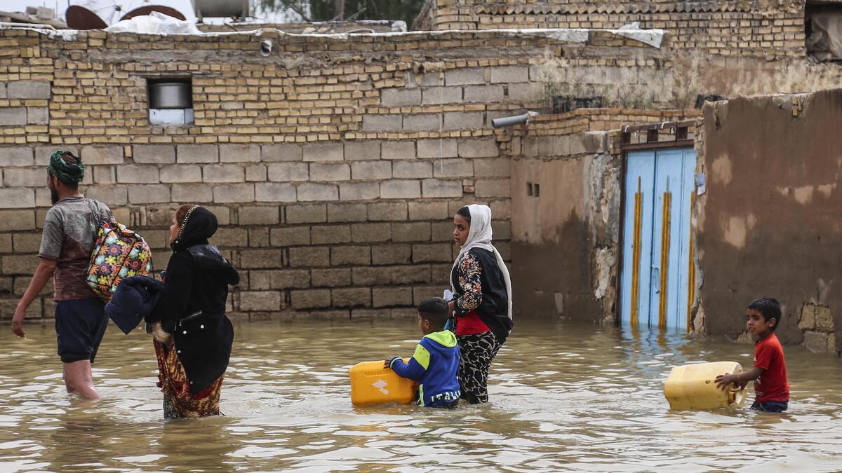 An Iranian family walks through a flooded street in a village around the city of Ahvaz, in Iran's Khuzestan province
Mehdi Pedramkhoo / TASNIM NEWS / AFP