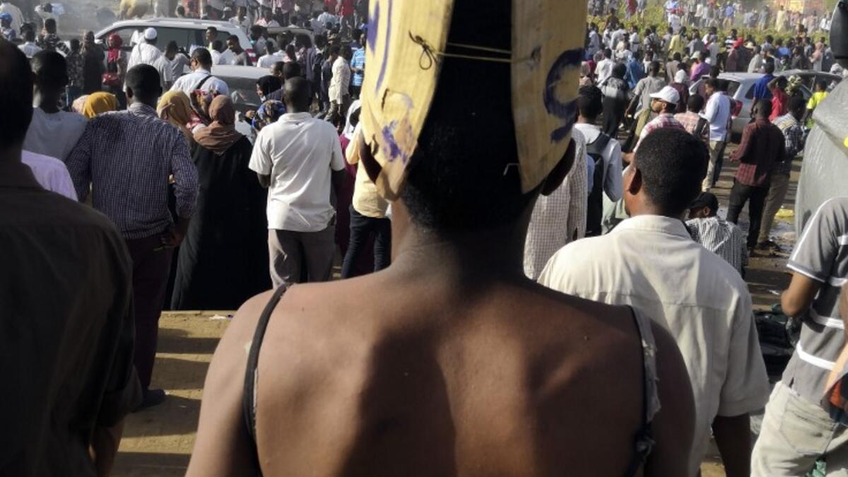 A Sudanese protester with a bare back walks with a sign behind reading in Arabic "Just fall that is all" during a demonstration in front of the military headquarters in the capital Khartoum on April 9, 2019.
AFP