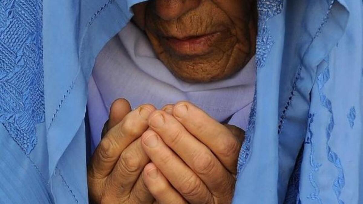 An Afghan woman prays during Eid al-Fitin Herat on August 8. (AFP)