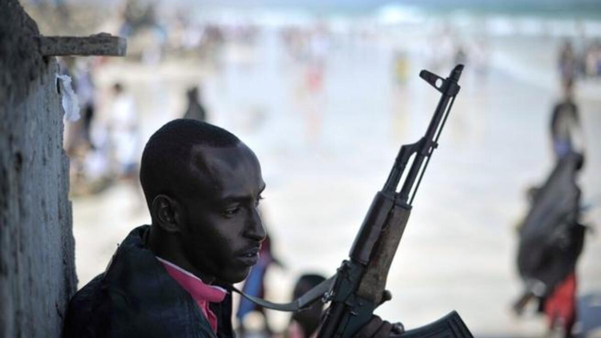 An armed guard stands watch as people celebrate Eid al-Fitr on Lido beach in Mogadishu. (AFP/AU/UN)