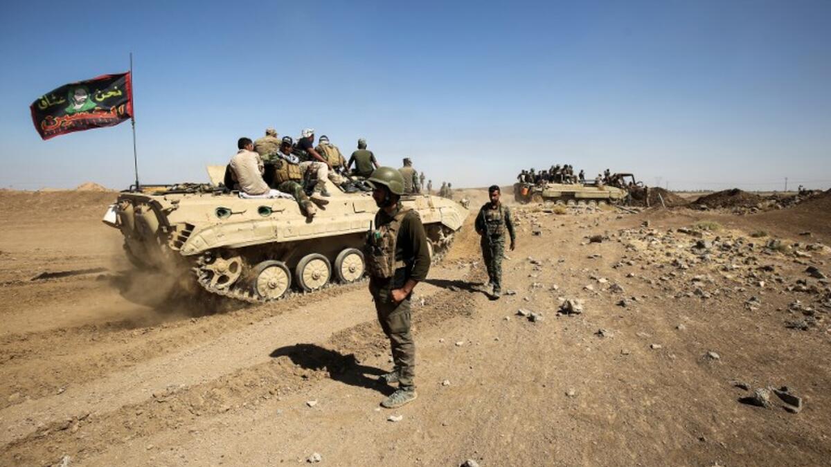 Fighters of the Hashed al-Shaabi (Popular Mobilization) paramilitaries are seen riding on infantry-fighting vehicles during the advance towards villages between the northern Iraqi cities of Hawija and Kirkuk on October 6, 2017
AHMAD AL-RUBAYE / AFP