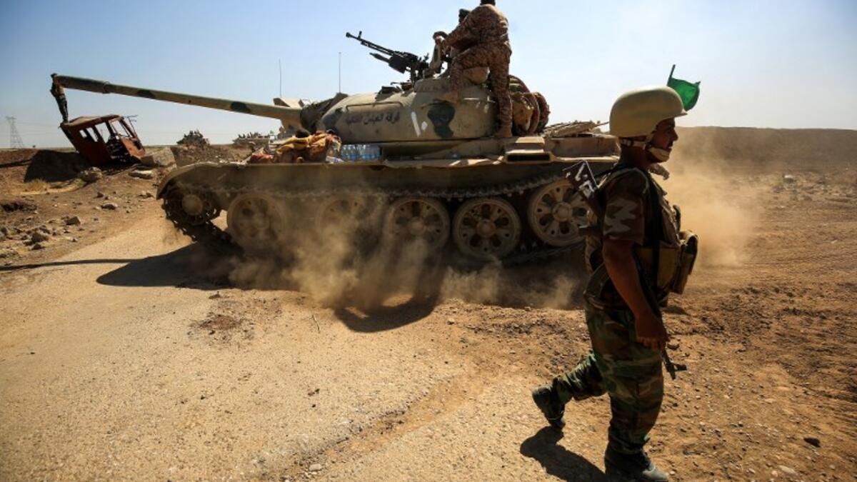 A picture taken on October 6, 2017 shows a tank belonging to the Furqat al-Abbas Brigade of the Hashed al-Shaabi (Popular Mobilisation) paramilitaries advancing towards villages between the northern Iraqi cities of Hawija and Kirkuk
AHMAD AL-RUBAYE / AFP