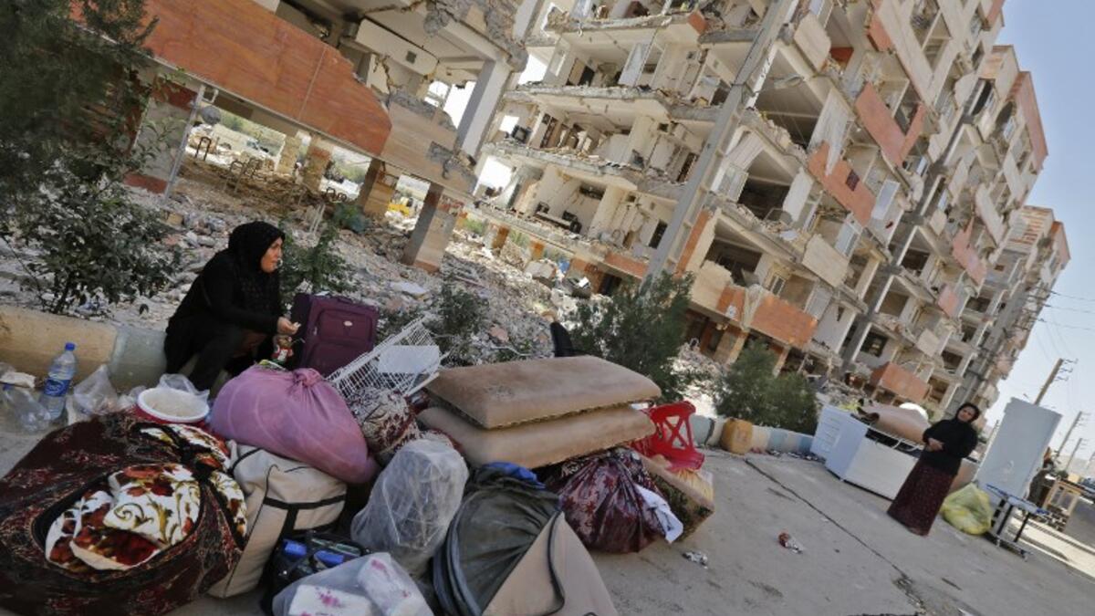 Iranians sit outside damaged homes after salvaging furniture and household appliances in the town of Sarpol-e Zahab in the western Kermanshah province near the border with Iraq.

(ATTA KENARE / AFP)