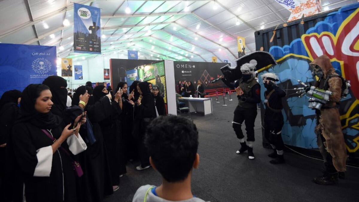 Saudi women uses their cell phones to take pictures of posing cosplayers during the first ever Comic-Con Arabia event held in the capital Riyadh on November 25, 2017. 
(FAYEZ NURELDINE / AFP)