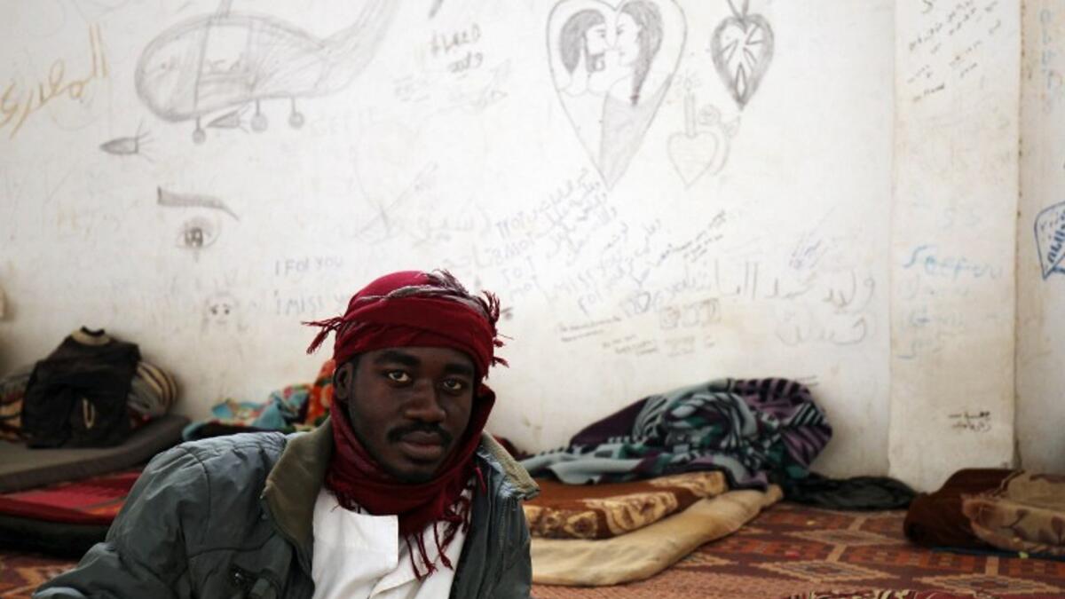 A sub-Saharan migrant sits at the Qanfouda detention center, in the southern outskirts of Benghazi, before being repatriated on Dec. 2, 2017. 
(Abdullah DOMA / AFP)