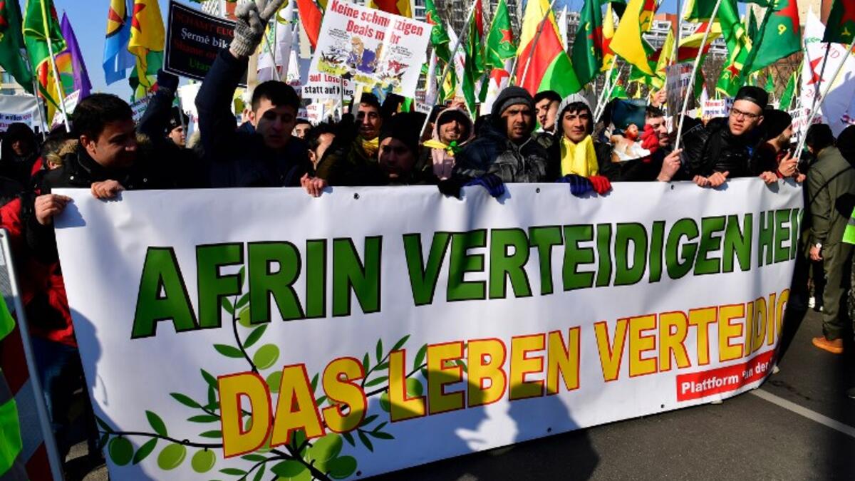 Protesters hold a giant banner reading "To defend Afrin means to defend life" during a demonstration of Kurdish groups to protest against Turkey's offensive against Kurds in Syria's Afrin region, on Mar. 3, 2018 in Berlin. 
(John MACDOUGALL / AFP)