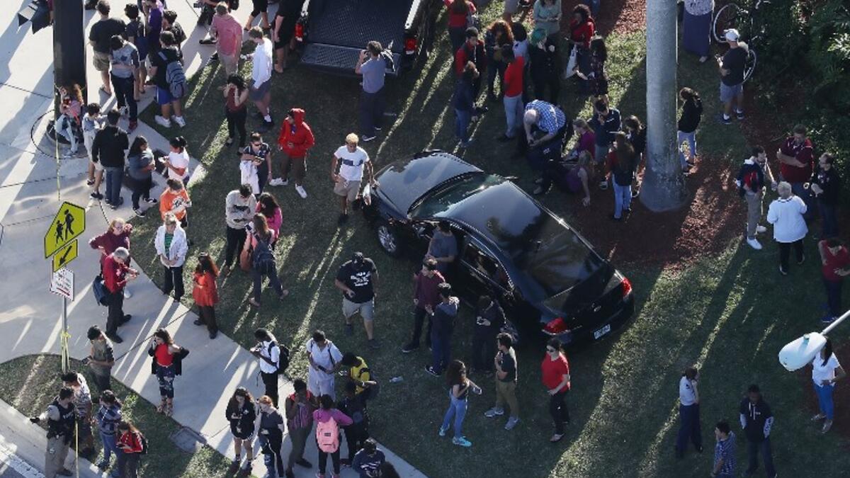 People wait for loved ones as they are brought out of the Marjory Stoneman Douglas High School after a shooting at the school that reportedly killed and injured multiple people on Feb. 14, 2018 in Parkland, Florida. Numerous law enforcement officials continue to investigate the scene.
(JOE RAEDLE / GETTY IMAGES NORTH AMERICA / AFP)