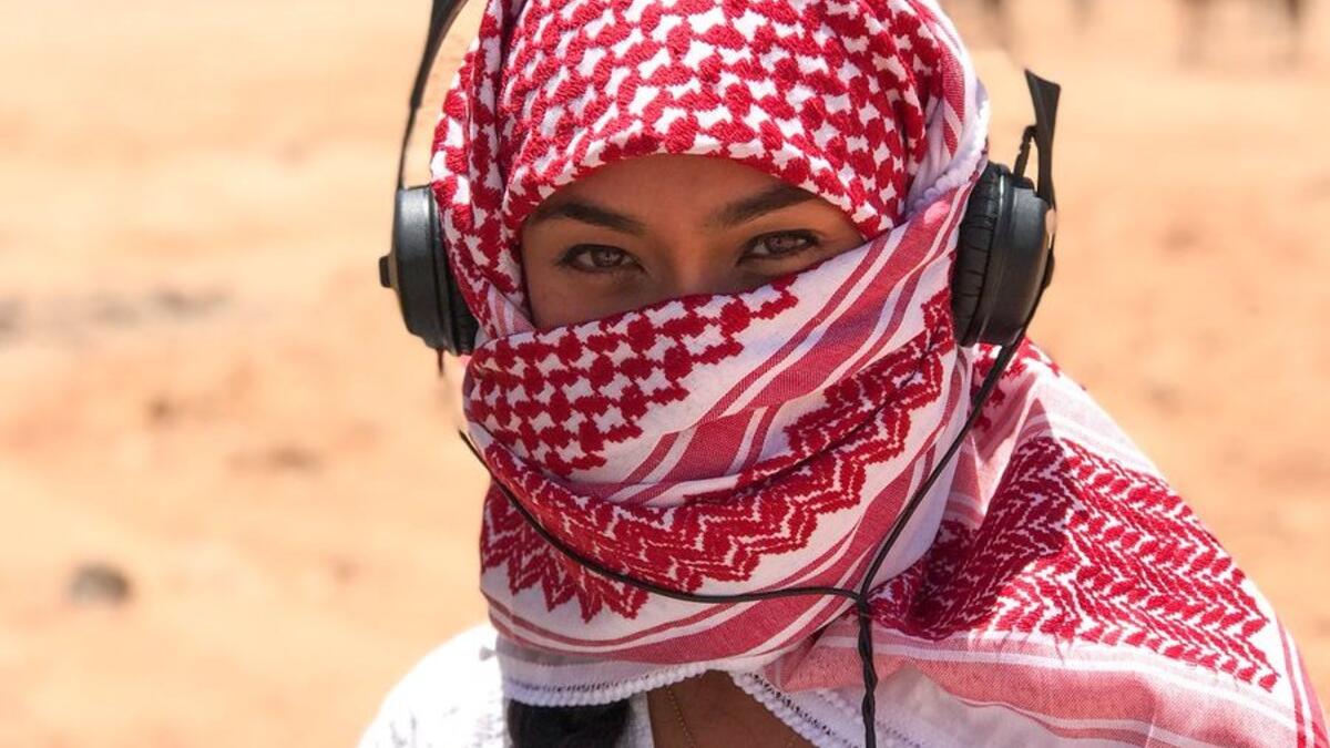 A girl in the Jordanian scarf listens to music in the Wadi Rum desert (Twitter)