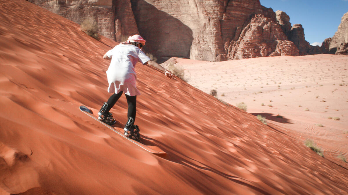 Girl sand boarding on dunes in Wadi Rum, Jordan (Shutterstock/File Photo)