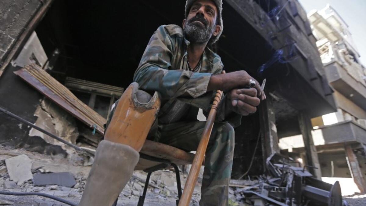A man sits in a street near destroyed buildings in the Palestinian camp of Yarmuk southern Damascus on November 1, 2018. 
LOUAI BESHARA / AFP