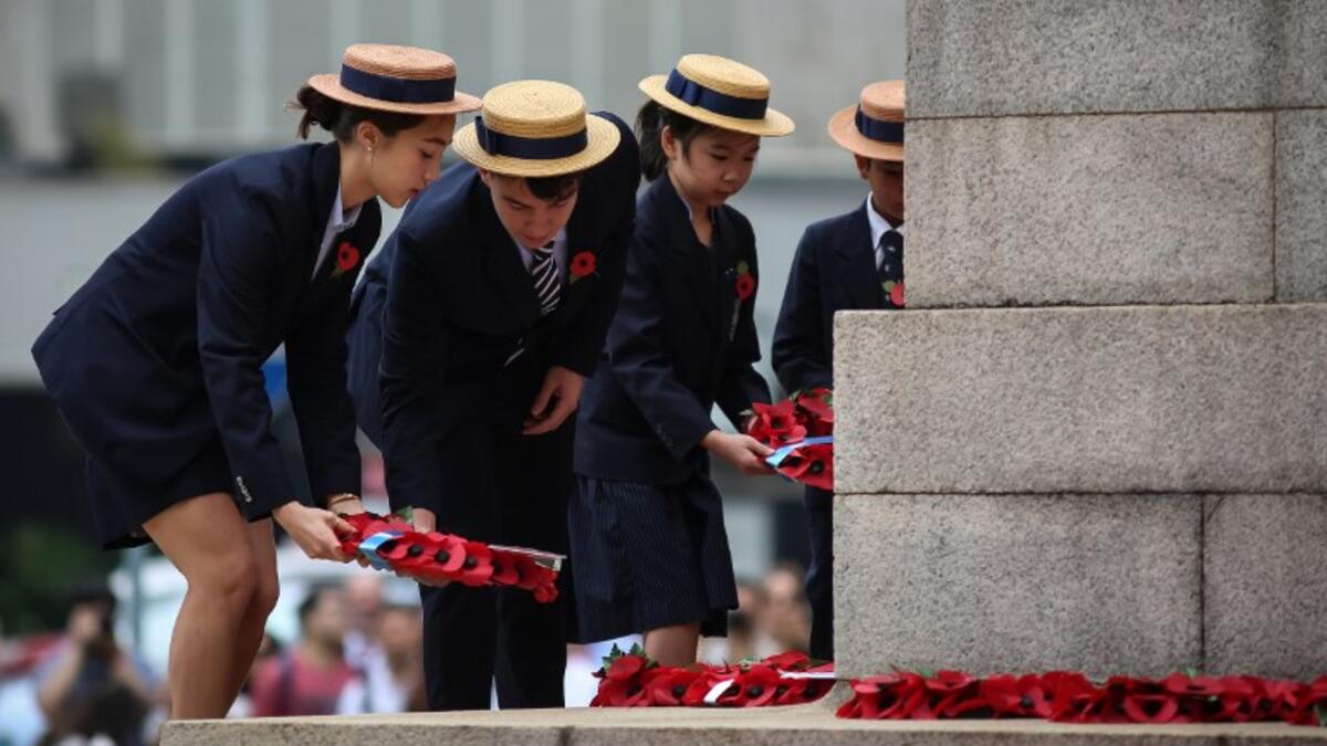 School children lay wreaths during a Remembrance Day ceremony honouring members of the armed forces who died in the line of duty at the Cenotaph marking the 100th anniversary of the end of World War I in Hong Kong on November 11, 2018. 
VIVEK PRAKASH / AFP