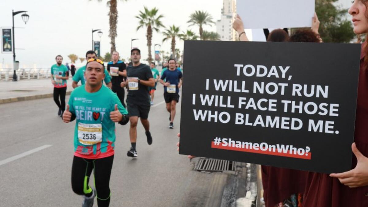 Activist holds a banner against sexual assaults during the 16th edition of the Beirut Marathon on November 11, 2018. 
ANWAR AMRO / AFP