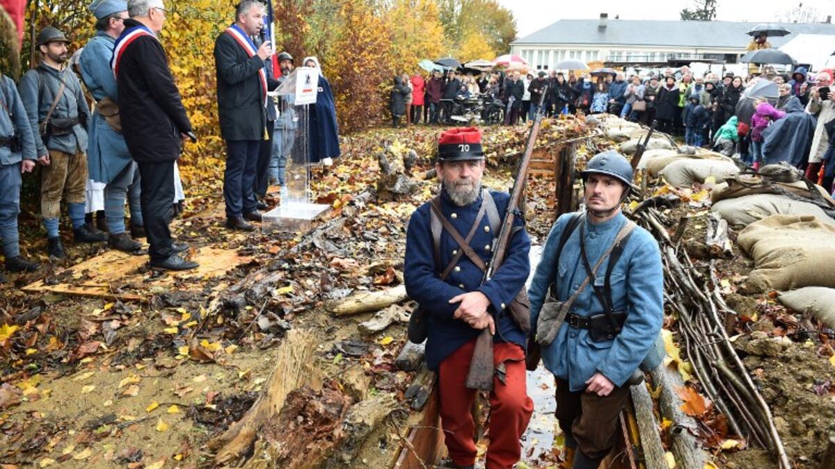 Inhabitants of Souille and La Guierche and history enthusiast, dressed with vintage army uniforms of Poilu (French soldier in World War I), stand guard in a reconstructed trench of the WWI, as they take part in a ceremony to inaugurate the trench on November 11, 2018 
JEAN-FRANCOIS MONIER / AFP