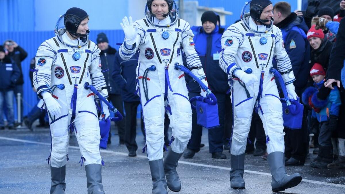 Members of the International Space Station (ISS) expedition 58/59, walk to report to Dmitry Rogozin (unseen), the head of the Russian space agency Roscosmos, prior to the launch onboard the Soyuz MS-11 spacecraft at the Russian-leased Baikonur cosmodrome in Kazakhstan on December 3, 2018. 
Kirill KUDRYAVTSEV / POOL / AFP