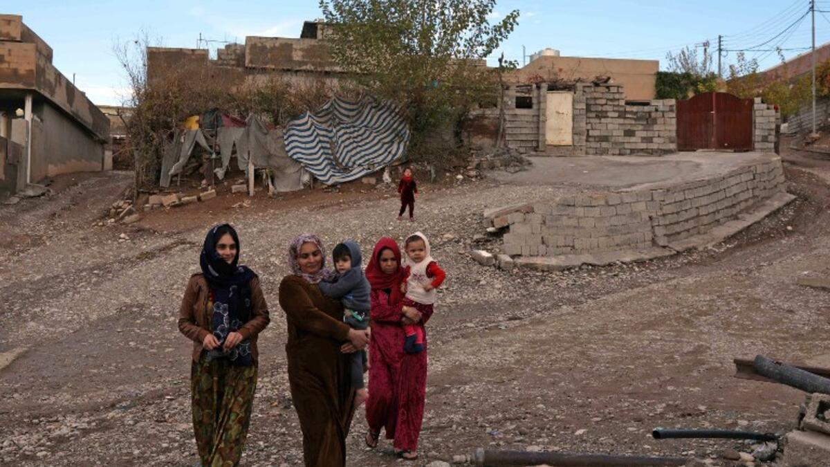 Women carry children as they walk in Sharboty Saghira, a small village east of regional capital Arbil.
SAFIN HAMED / AFP
