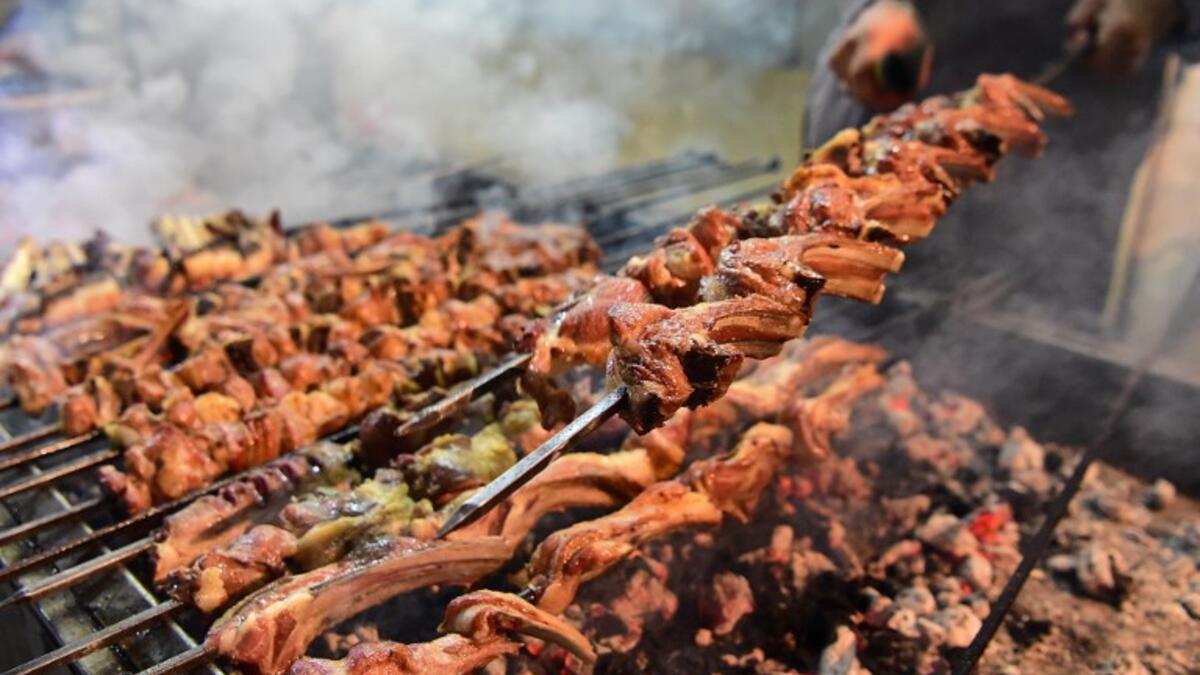 Pakistani man cooks grilled meat at the Charsi (Hashish) Tikka restaurant in Namak Mandi in Peshawar.
ABDUL MAJEED / AFP