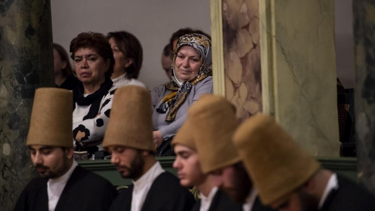 People look at whirling dervishes performing during a ceremony marking the anniversary of the death of Jelaleddin Mevlana Rumi, Sufi mystic, poet and founder of the sufism on December 16, 2018 at Galata Mevlihanesi in Istanbul. 
Yasin AKGUL / AFP