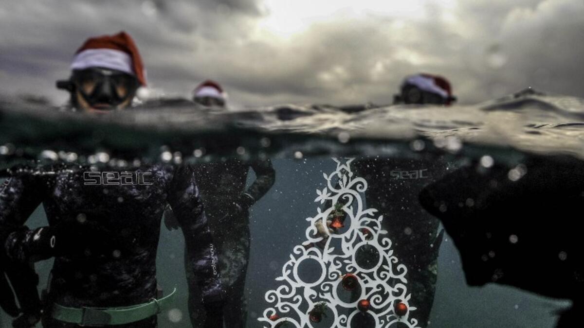 Freedivers pose with an ornamental Christas tree near the surface before diving to place it on the sea-floor off the coast of the northern Lebanese port city of Tripoli on December 18, 2018. 
IBRAHIM CHALHOUB / AFP