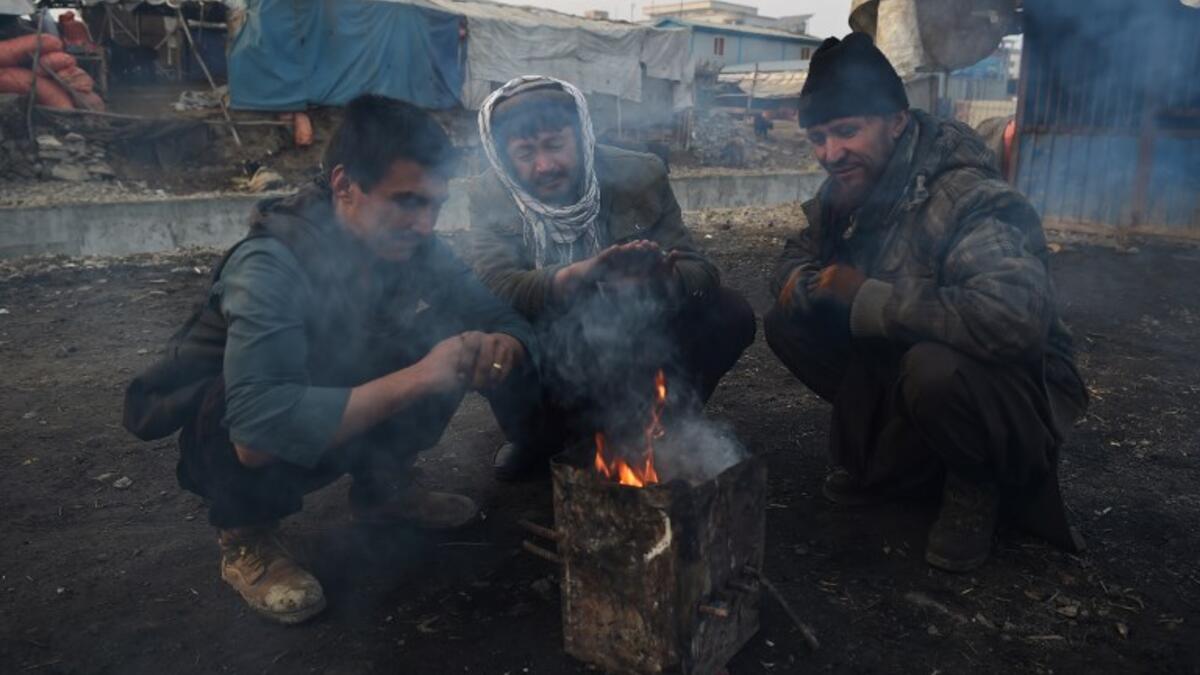 In this photograph, Afghan charcoal vendors warm up around a fire amid heavy smog conditions in Afghanistan's capital Kabul. 
WAKIL KOHSAR / AFP