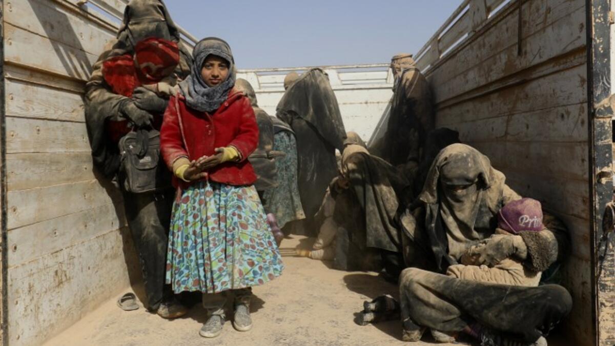 People who fled battles between Syrian Democratic Forces (SDF) and ISIS fighters in the Syrian village of Baghouz, arrive after crossing a desert in the back of a truck to a region controlled by the SFD in the countryside of the Deir Ezzor province 
Delil SOULEIMAN / AFP