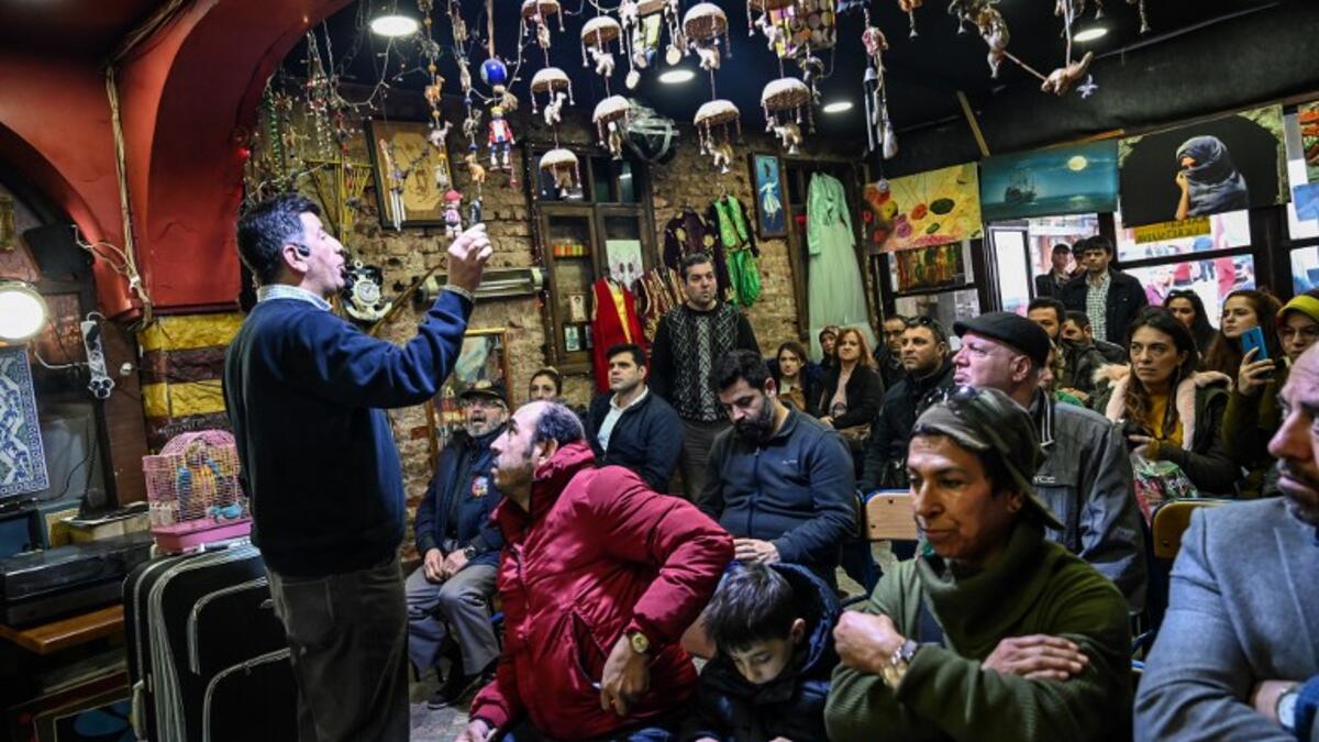 An auctioneer shows items to the audience at an auction house in Istanbul's Balat district.
OZAN KOSE / AFP