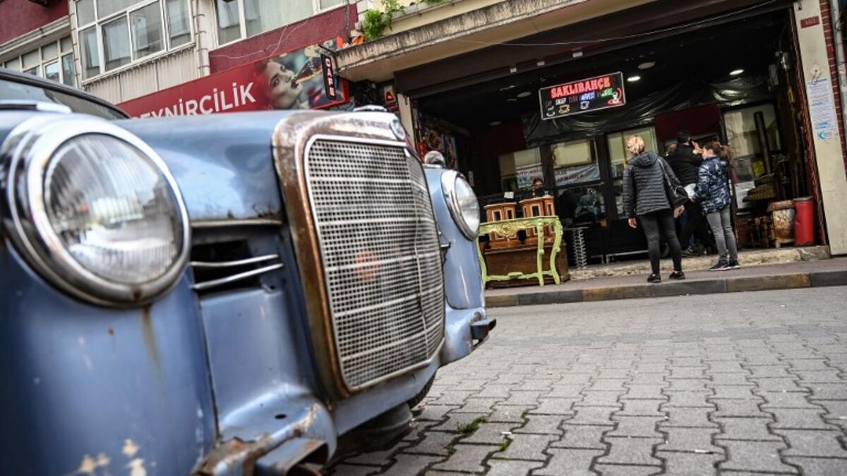 People stay outside an auction house in Istanbul's Balat district.
OZAN KOSE / AFP